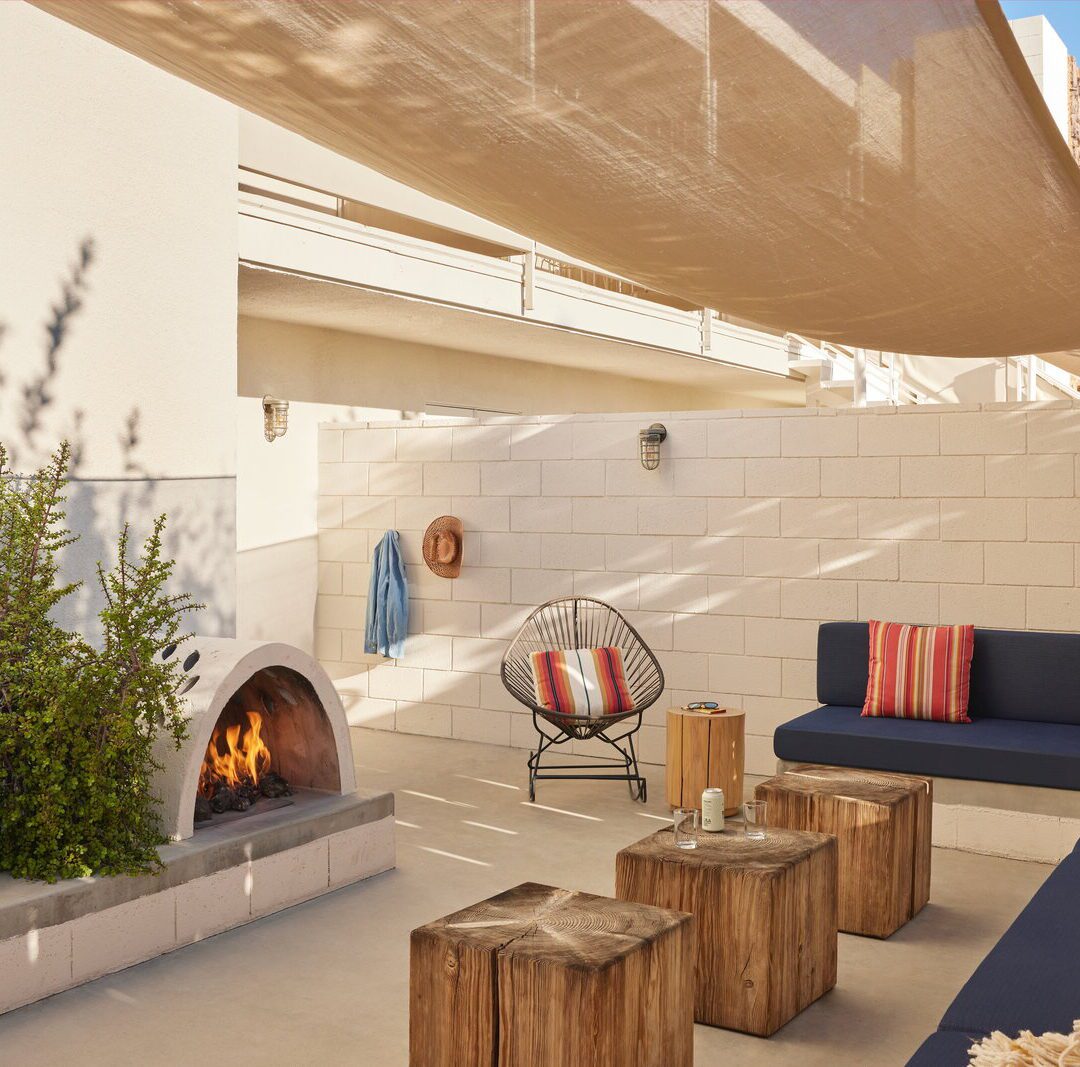 A long blue couch sits across from a fireplace, providing a large amount of seating and privacy
