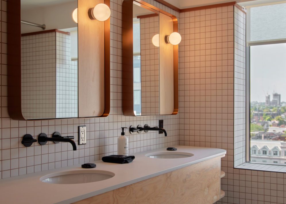 Two vanity areas include sinks and well lit mirrors for two people to prepare simultaneously